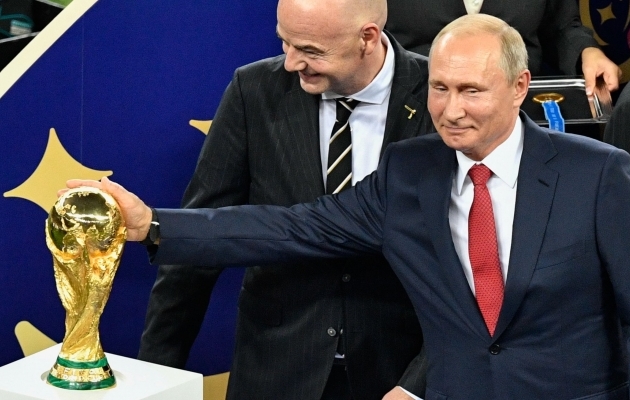 Venemaa president Vladimir Putin sirutab 2018. aasta MM-finaali järel käe vargsi karika järele. FIFA presidendi Gianni Infantino tuju on hea. Foto: Scanpix / AFP Photo / Aleksandr Nemenov