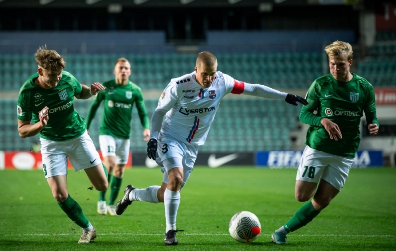 Henrik Ojamaa Flora mängijate vahel palliga. Foto: Liisi Troska / jalgpall.ee